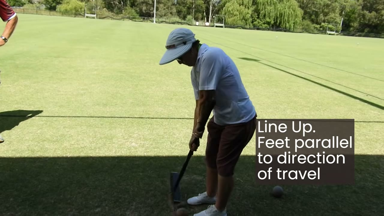 Sue setting up over a ball, on-screen caption: 'Line Up. Feet parallel to direction of travel.'